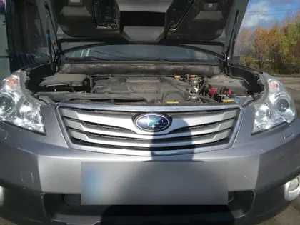 Subaru gri cu capota deschisă, vedere din față a farurilor