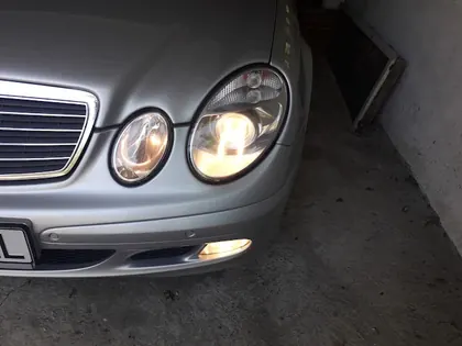 Mercedes argintiu cu farurile rotunde aprinse și lentile transparente